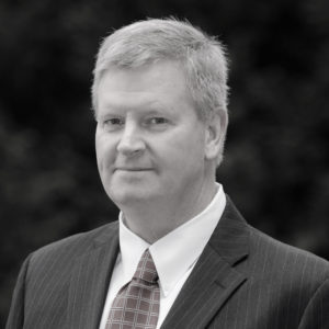 A headshot of a male with a jacket and tie