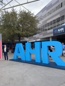 Man standing in front AHR Expo Hall in Las Vegas of 3D letters outside, letters are AHR